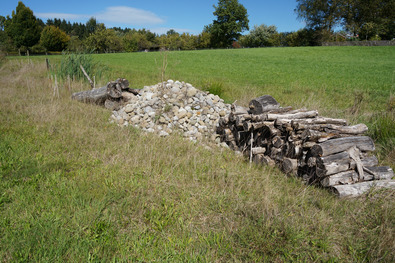 Asthaufen und Holzbeige an einem Wassergraben